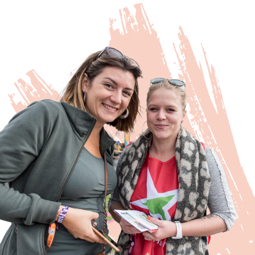 Deux jeunes membres du PTB sourient à la caméra.