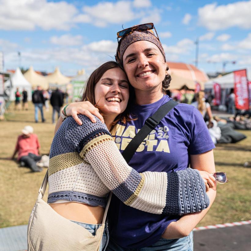 Deux jeunes femmes bénévoles se font une accolade à ManiFiesta