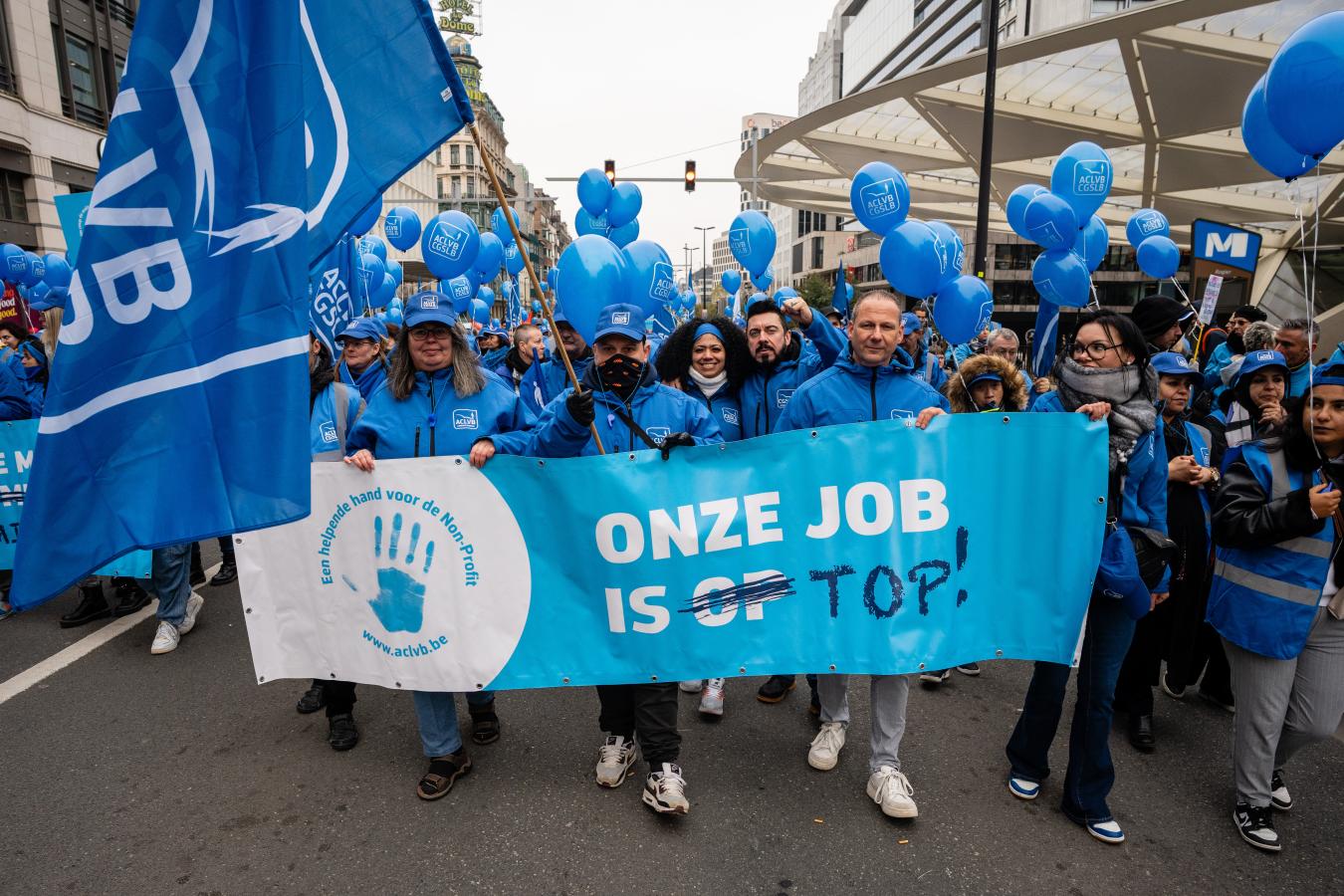 Des manifestants de la CGSLB avec une banderole : « Notre job est top. »