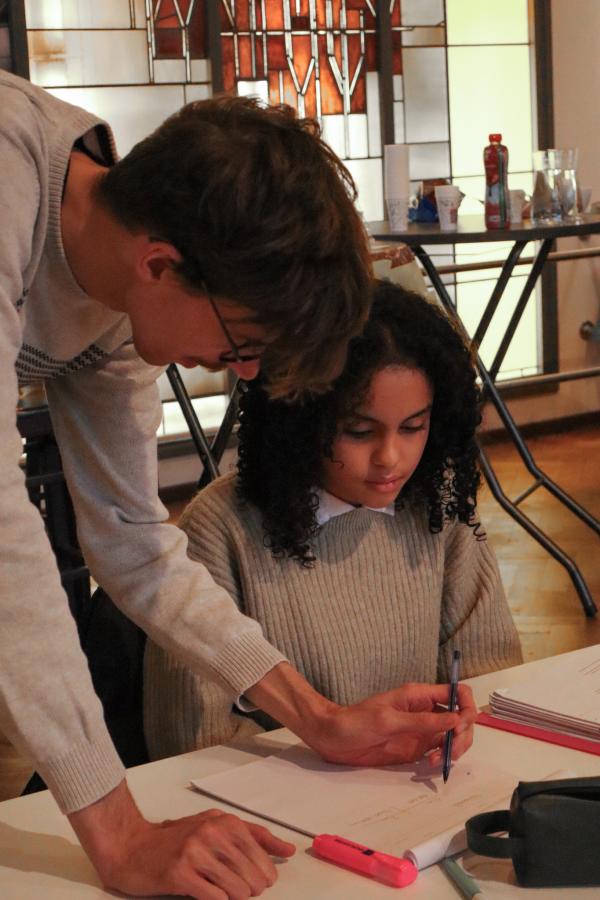 Un bénévole aide une élève à étudier aux Boostdays de RedFox