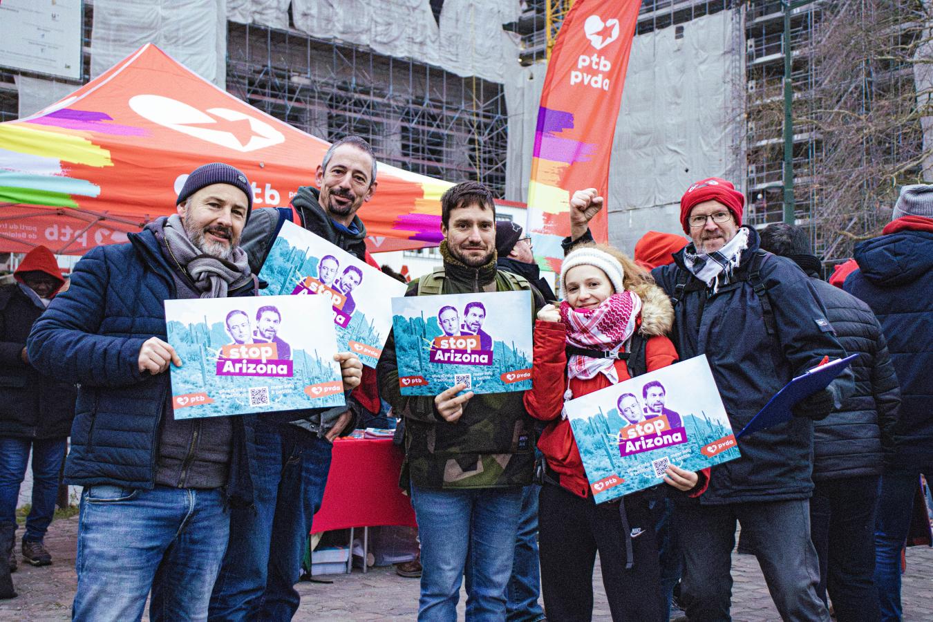 Un groupe de membres du PTB avec des pancartes « Stop Arizona ».