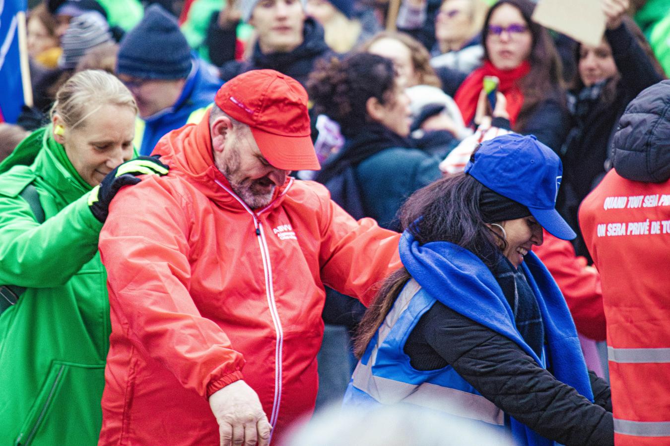 Des syndicalistes des trois couleurs font une chenille lors d'une action.