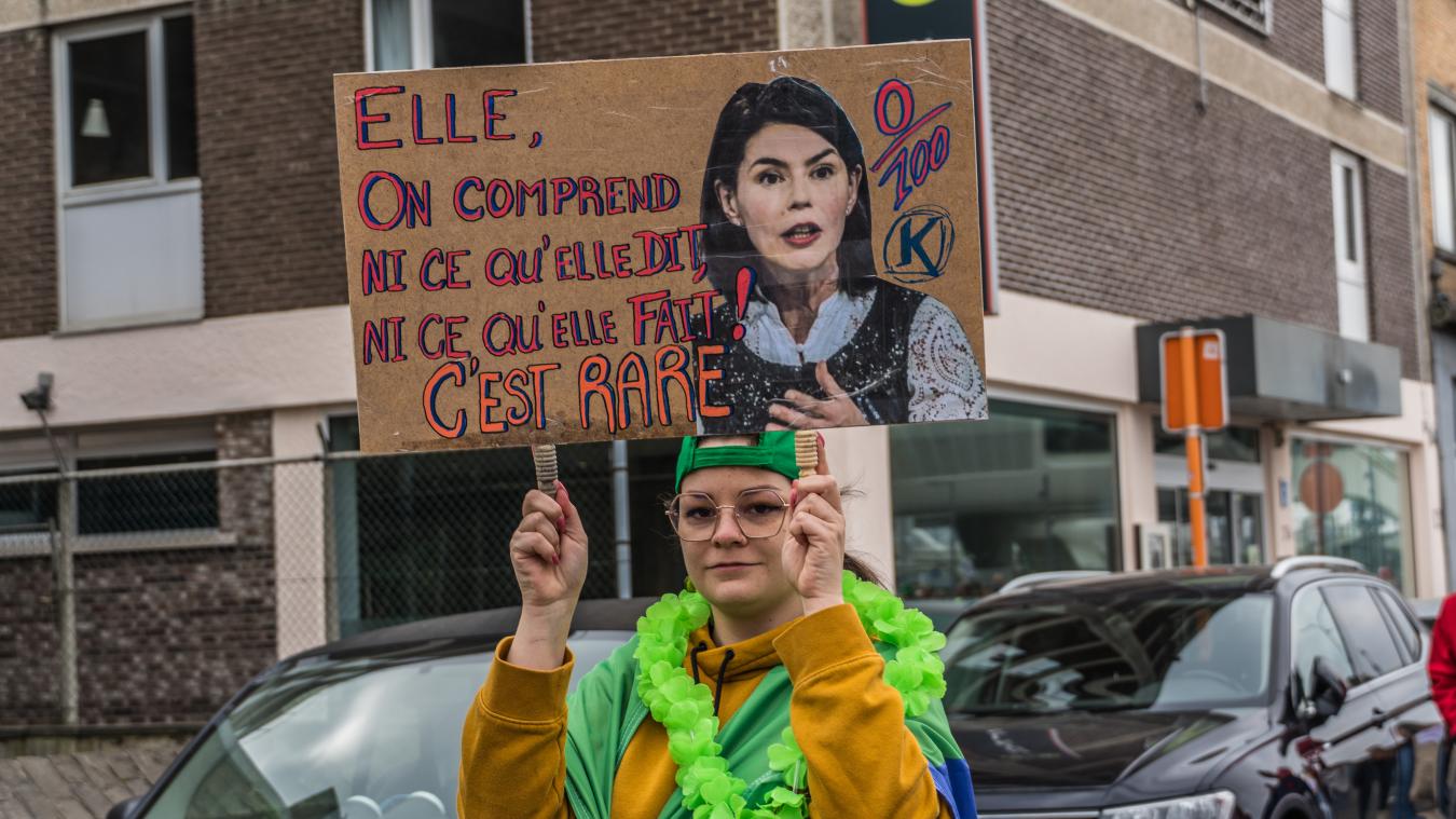 Photo d'une jeune de la CSC avec une pancarte représentant la ministre Glatigny : "Elle comprend ni ce qu'elle dit, ni ce qu'elle fait, c'est rare. 0/100"