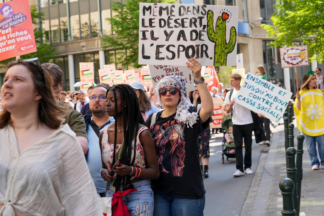Une jeune femme marche avec une pancarte "Même dans le désert, il y a de l'espoir"