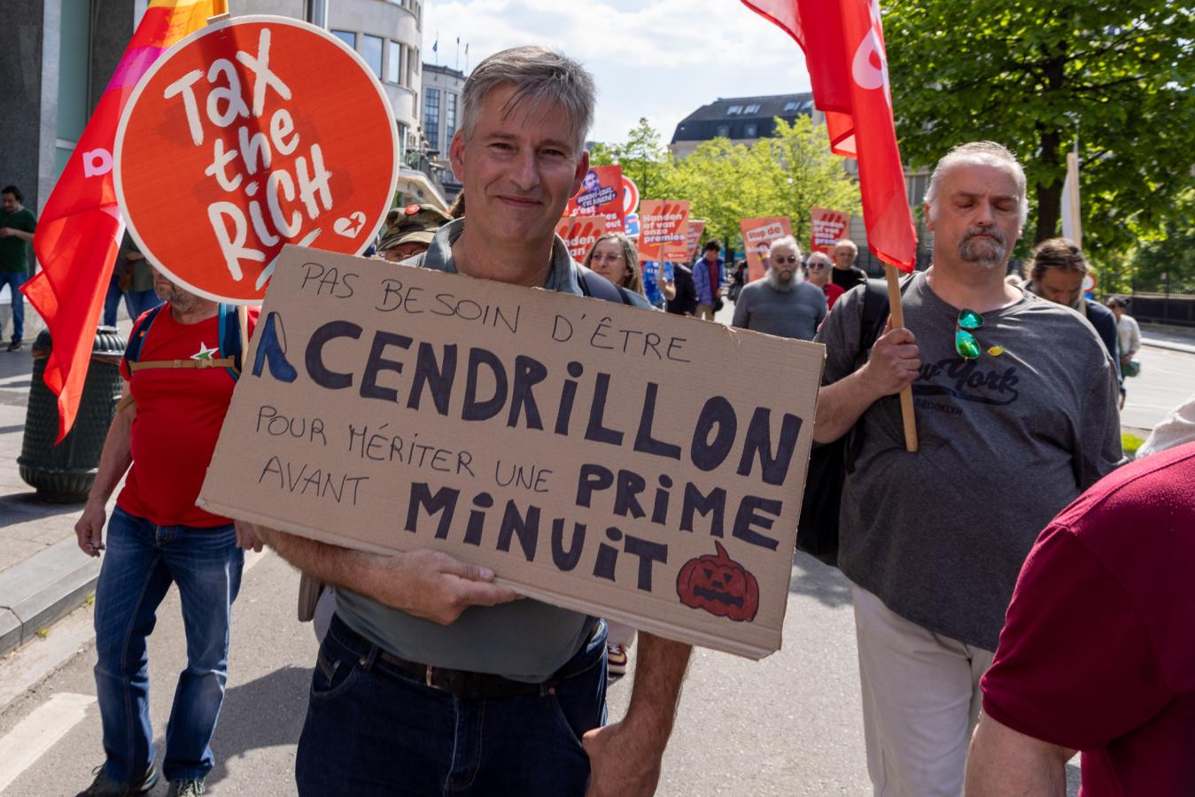 Un homme porte une pancarte : "Pas besoin d'être Cendrillon pour mériter une prime avant minuit"