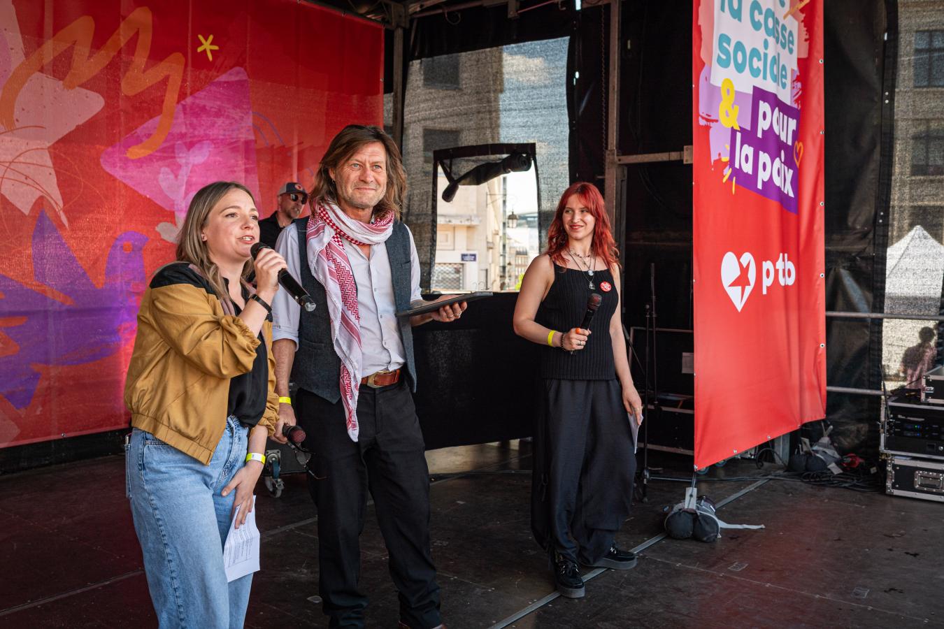 Photo des animatrices sur la scène de la marche, avec le militant pour la paix invité