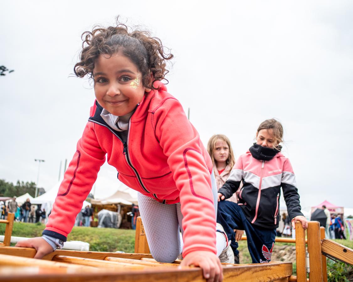 Une petite fille grimpe sur un module de jeu