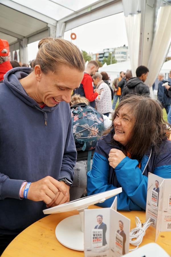 Un homme et une femme se sourient devant une tablette