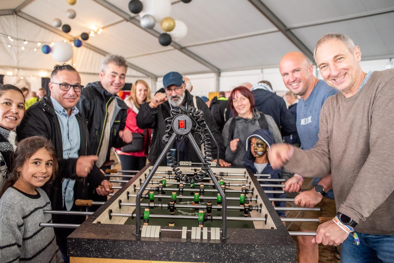 Un groupe de personnes réunies autour d'un babyfoot