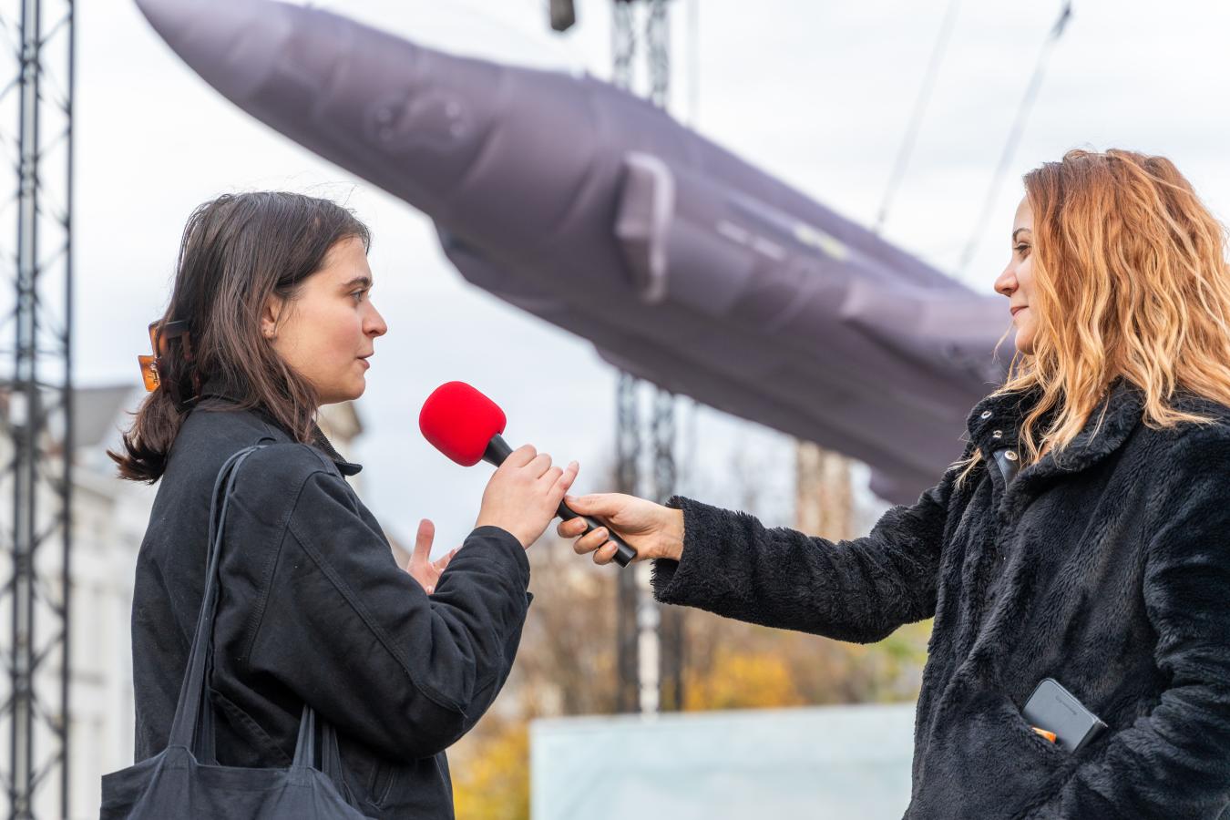 Une femme tend le micro pour interviewer une autre femme