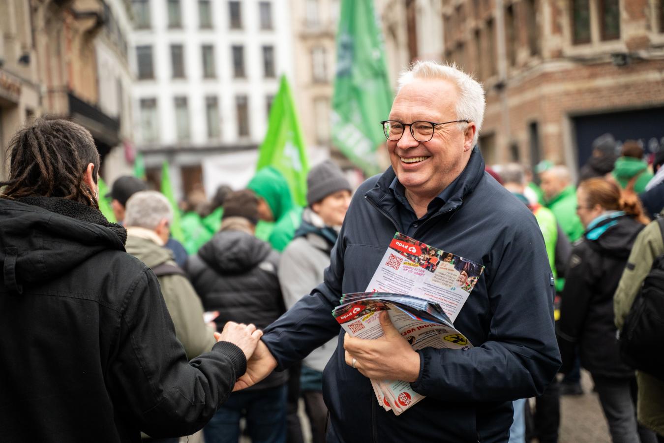 Peter Mertens distribue des flyers lors de la journée d'actions du 10 février à Anvers