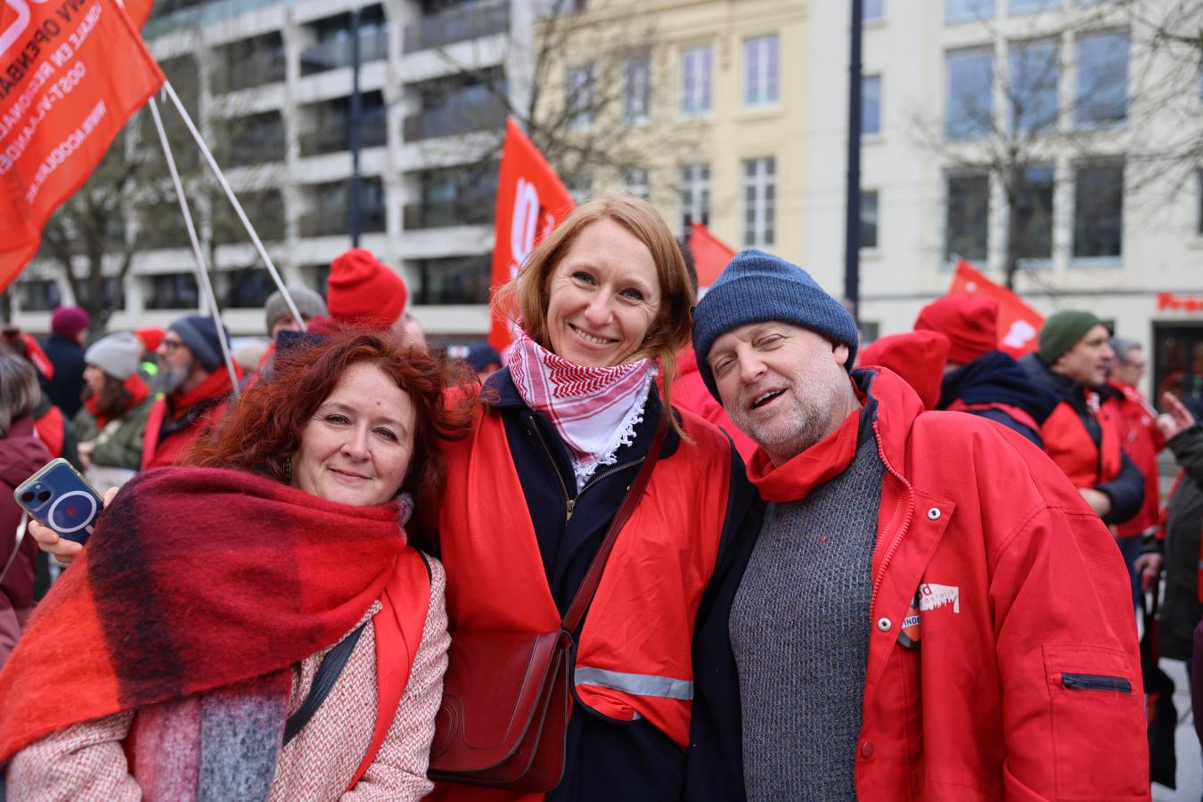 Groupe de trois personnes en rouge lors de la journée d'actions du 5 février 2026