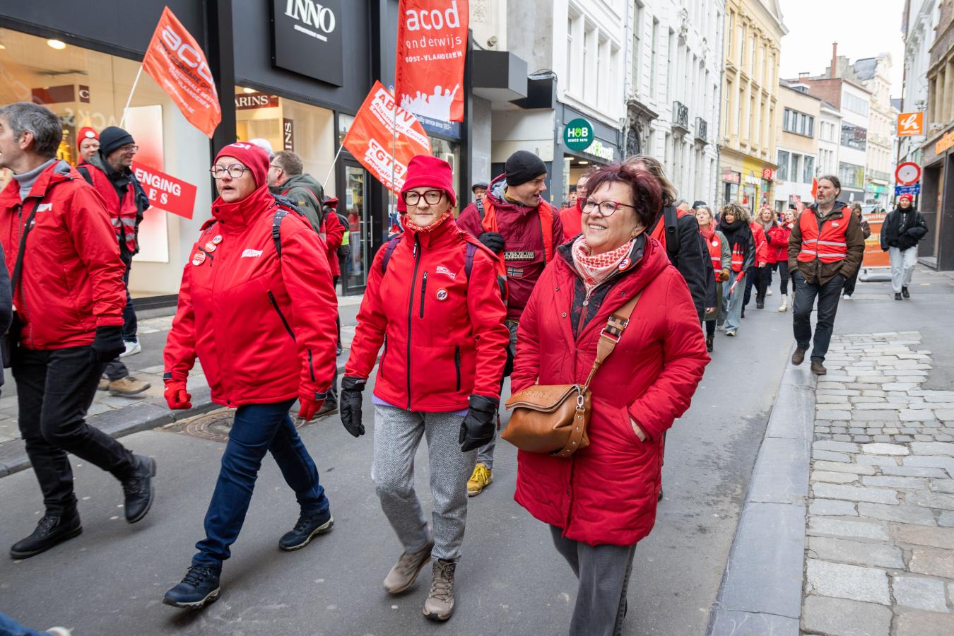 Trois femmes en tenue syndicale rouge défilent à Gand pour la journée d'actions du 5 février 2026