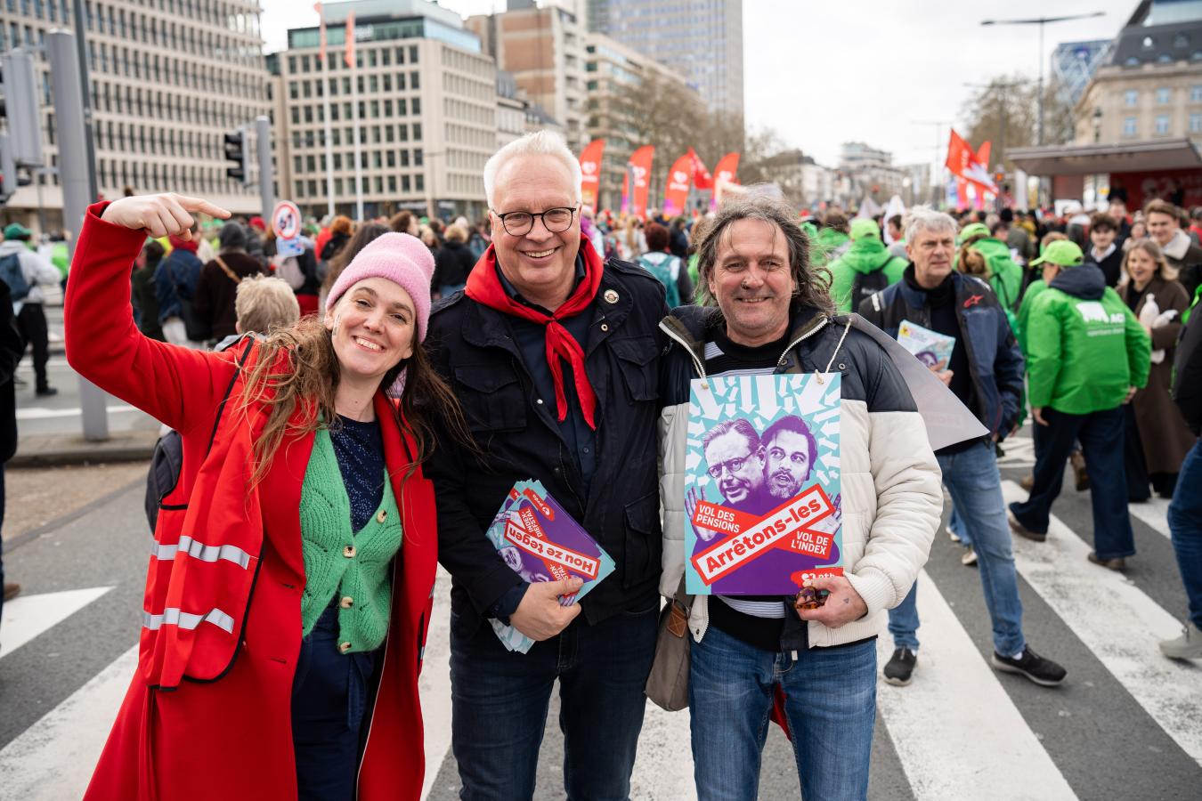 Peter Mertens avec deux travailleurs, l'un tient une pancarte "Arrêtons-les"
