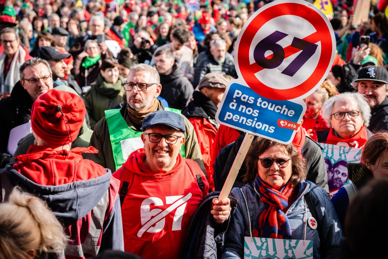 Un homme au milieu de la foule tient une pancarte 67 barré "Pas touche à nos pensions"