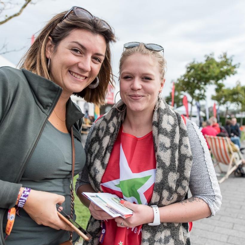 Twee leden van de PVDA glimlachen.