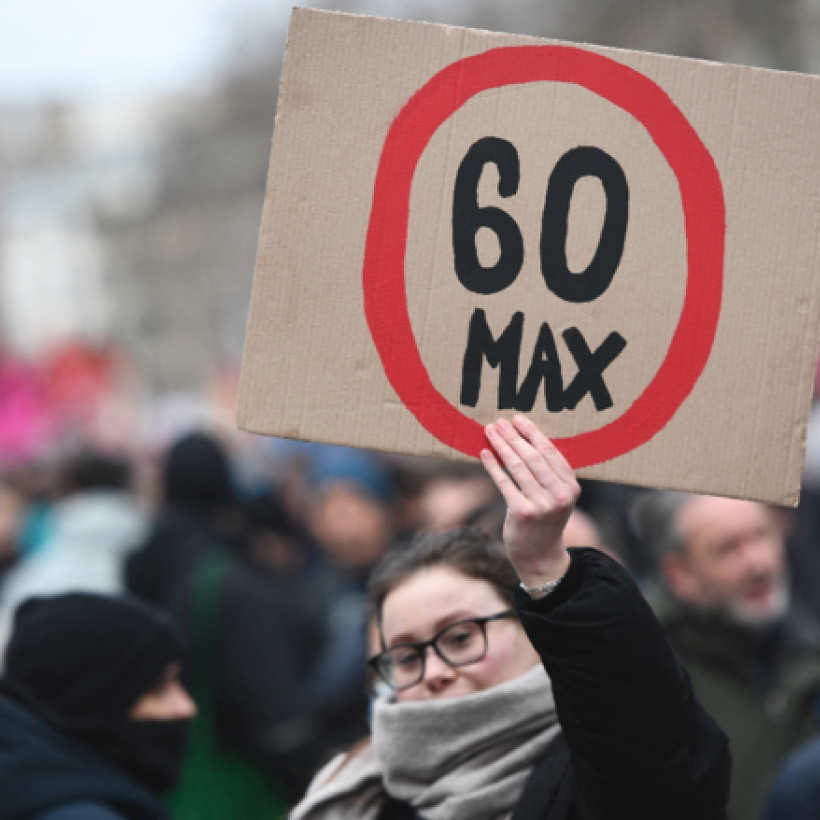 Une manifestante brandit une pancarte avec écrit "60" cerclé de rouge.