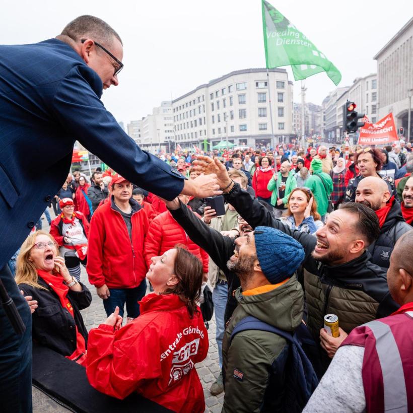 Raoul Hedebouw salue des manifestants depuis un podium.