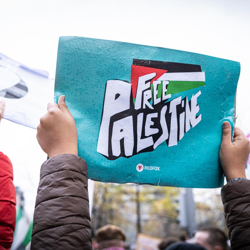 Twee handen houden een bord omhoog met de boodschap ‘Free Palestine’