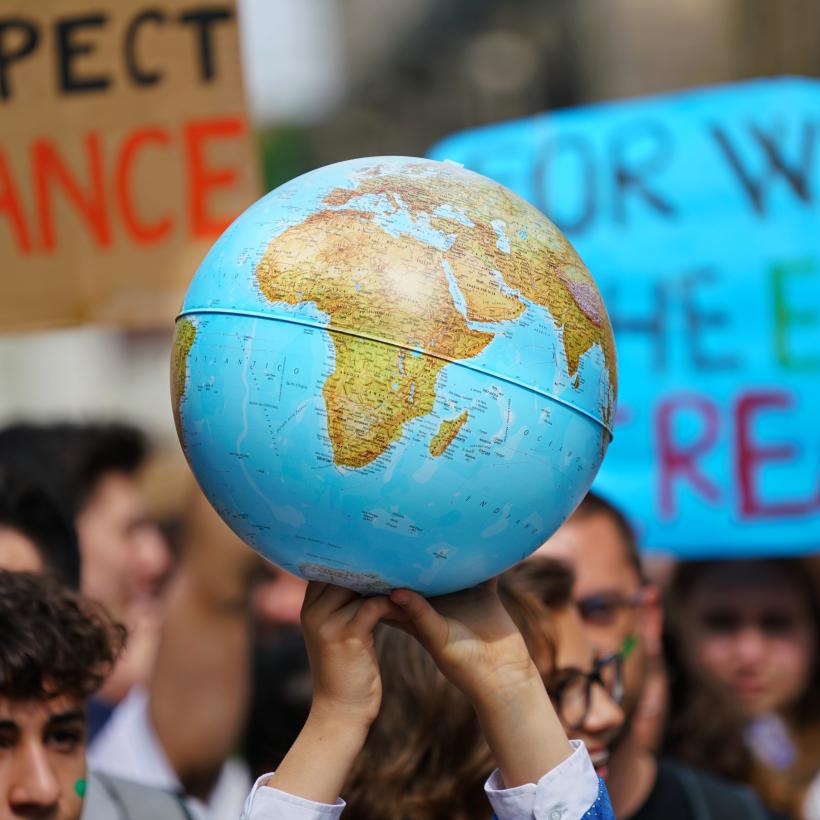 Des mains portent un globe terrestre lors d'une manifestation pour le climat.