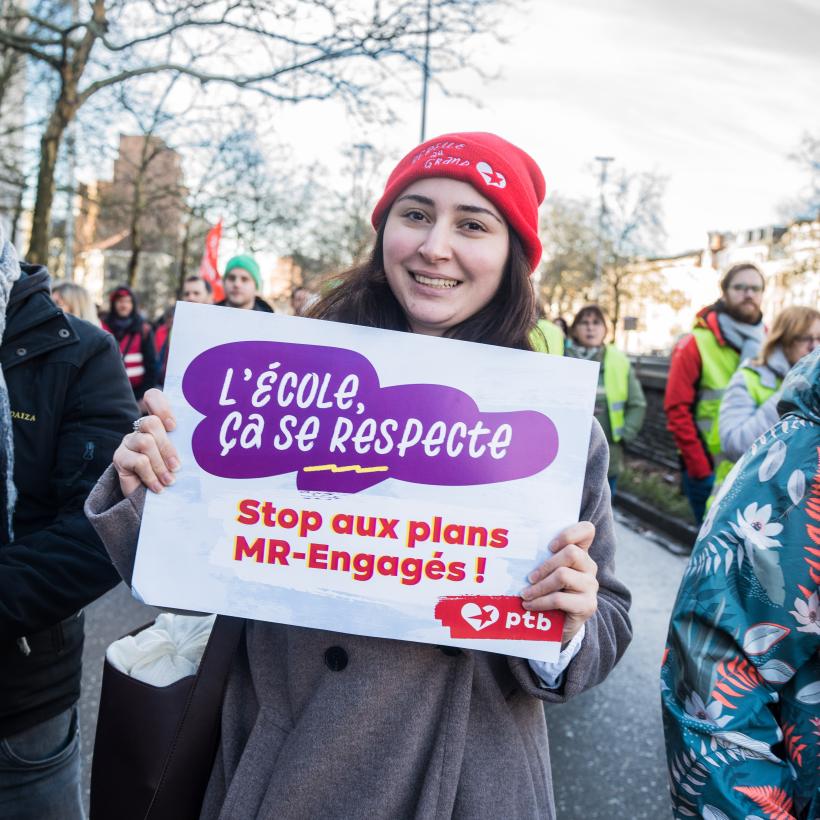 Une jeune fille portant une pancarte "L'enseignement, ça se respecte" lors de la manifestation du 27 janvier 2025 à Bruxelles
