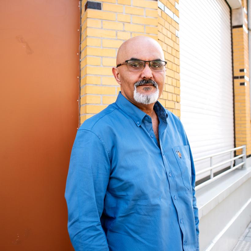 Un homme avec des lunettes regarde la caméra