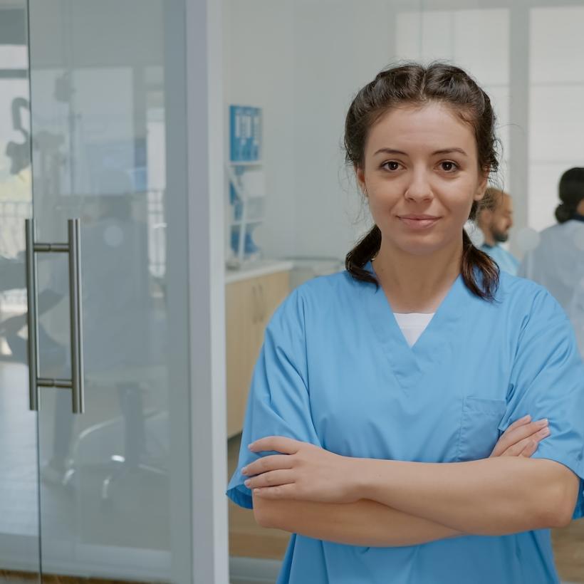 Une infirmière regarde l'objectif en croisant les bras