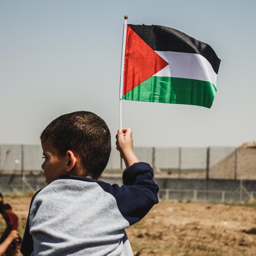 Un petit garçon tenant un drapeau palestinien