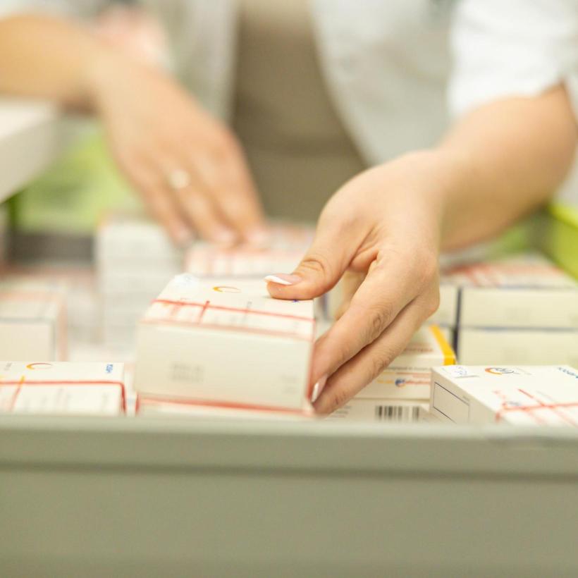 Une pharmacienne range des médicaments dans un tiroir