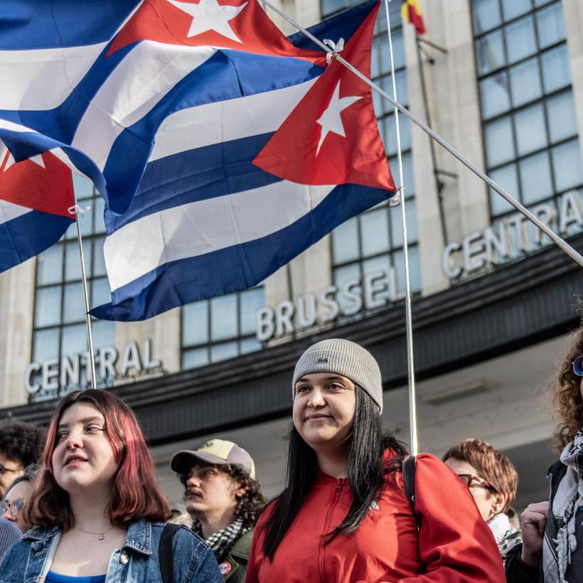 Groupe de jeunes avec des drapeaux cubains derrière eux lors de l'action "Pas touche à Cuba" à Bruxelles le 7 février 2026