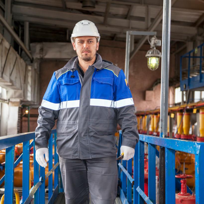 Un ouvrier dans un entrepôt regarde droit vers l'objectif.