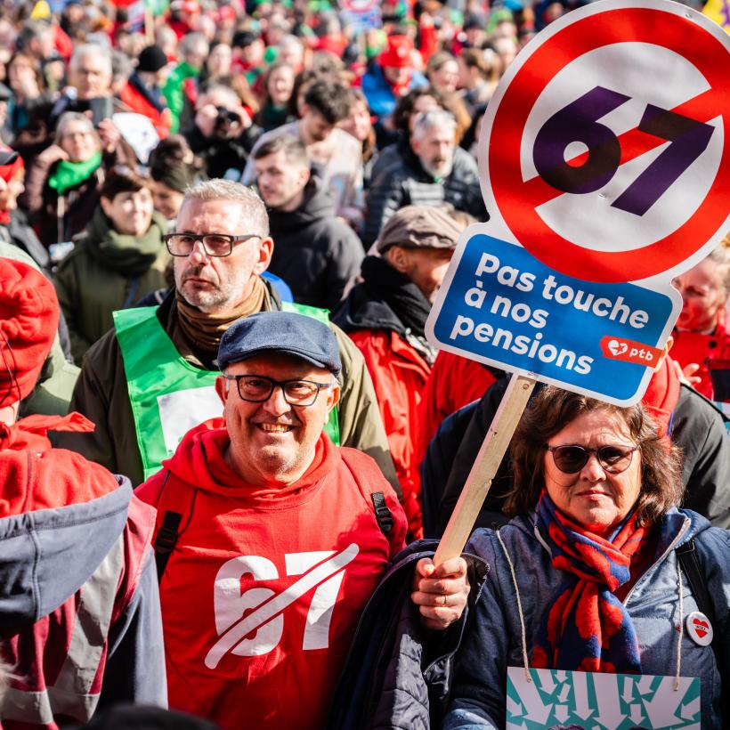 Un homme au milieu de la foule tient une pancarte 67 barré "Pas touche à nos pensions"