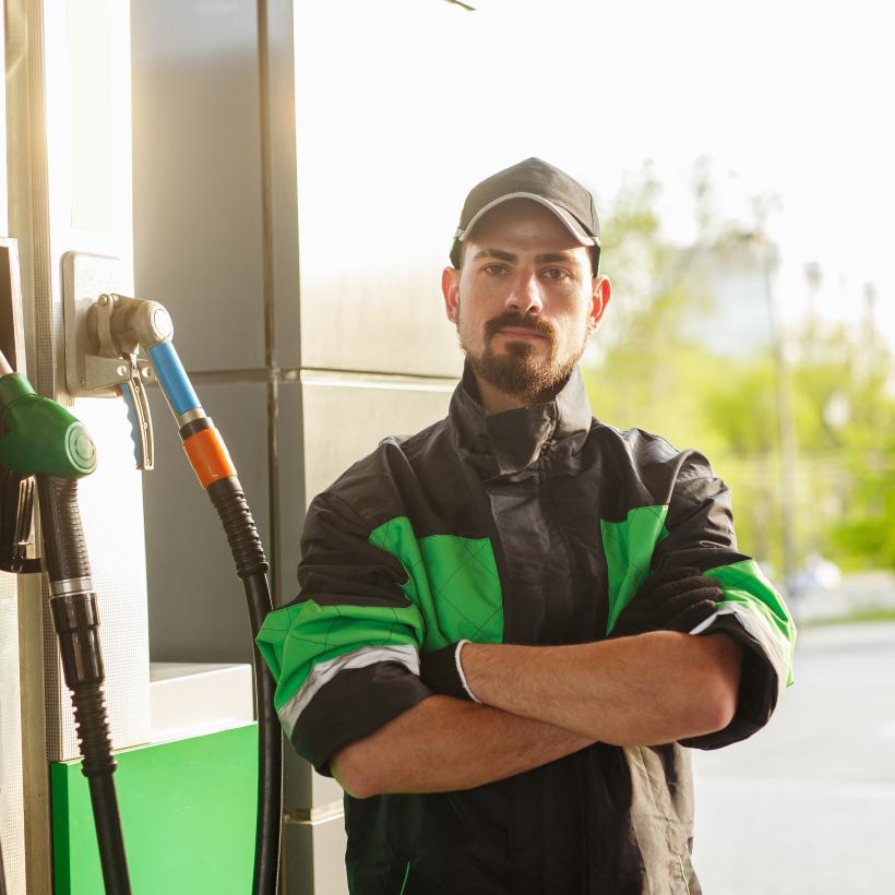 un homme se tient devant une pompe à essence