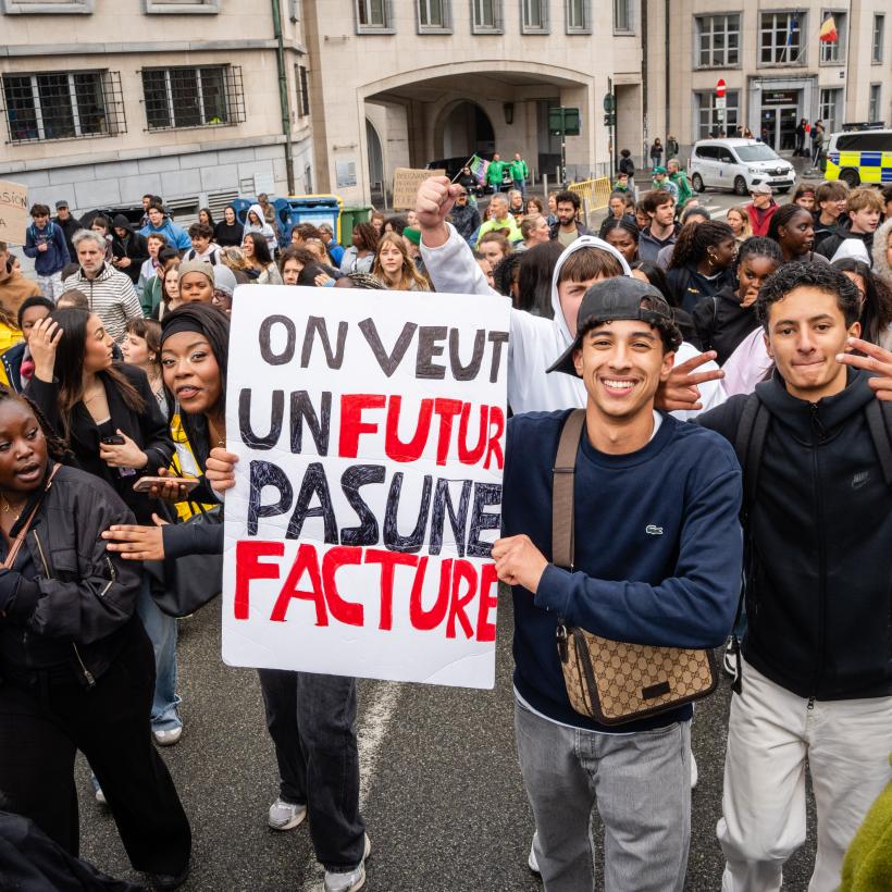 Des jeunes lors d'un rassemblement avec une pancarte "On veut un futur, pas une facture"