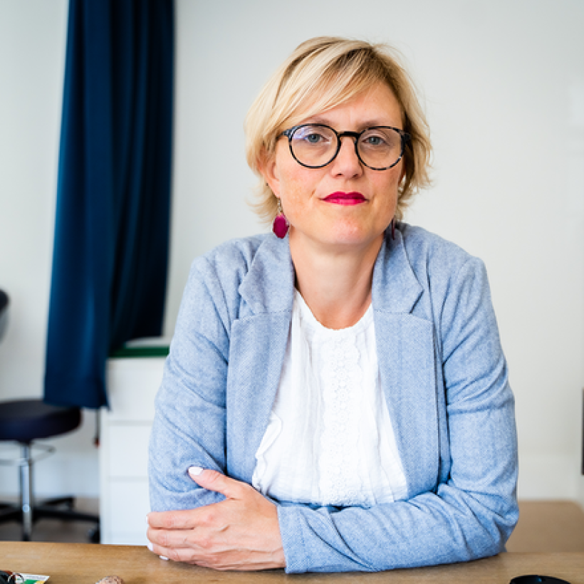 Sofie Merckx assise à son bureau dans son cabinet médical.