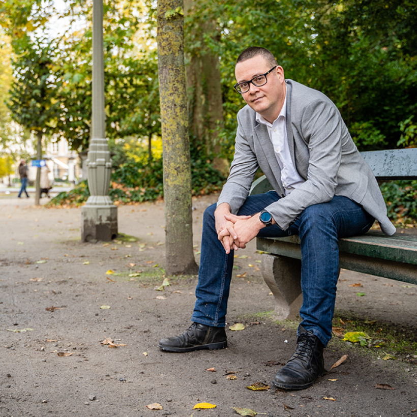 Raoul Hedebouw op een bankje in een park