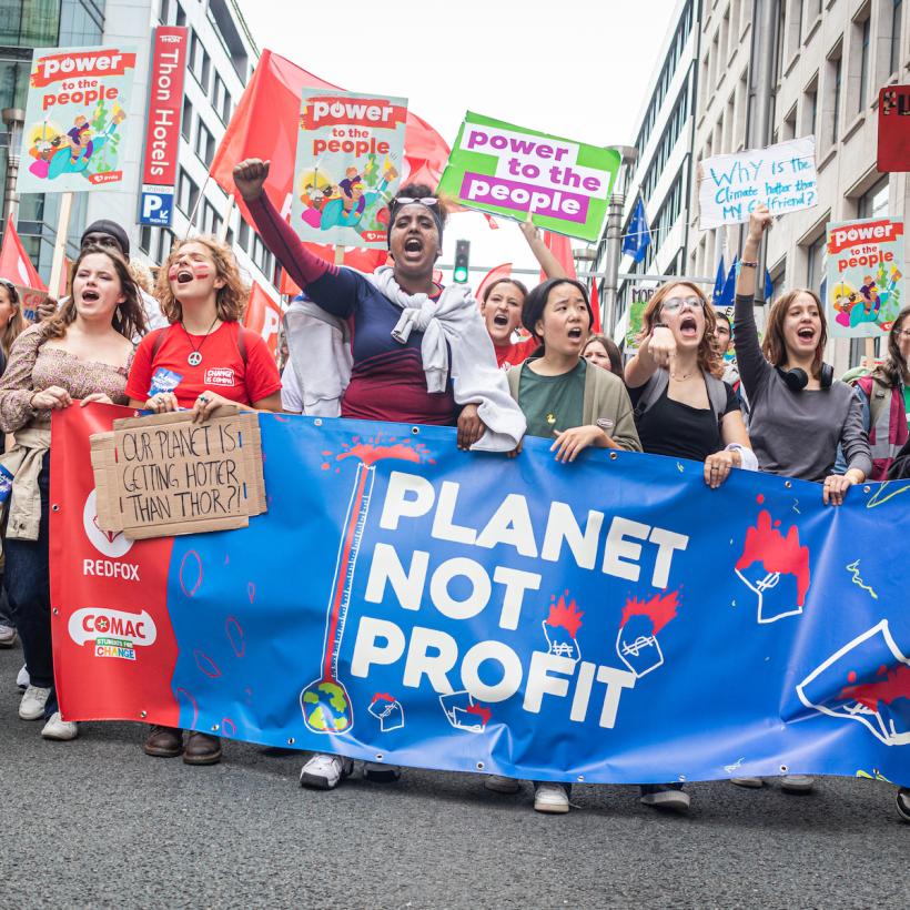 Jongeren van PVDA-studentenbeweging Comac achter een spandoek “People not profit”, tijdens een klimaatbetoging in 2022.