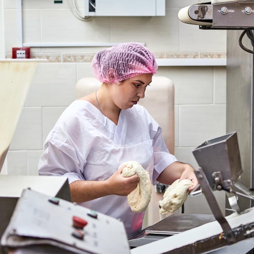 Vrouw aan het werk in een industriële bakkerij