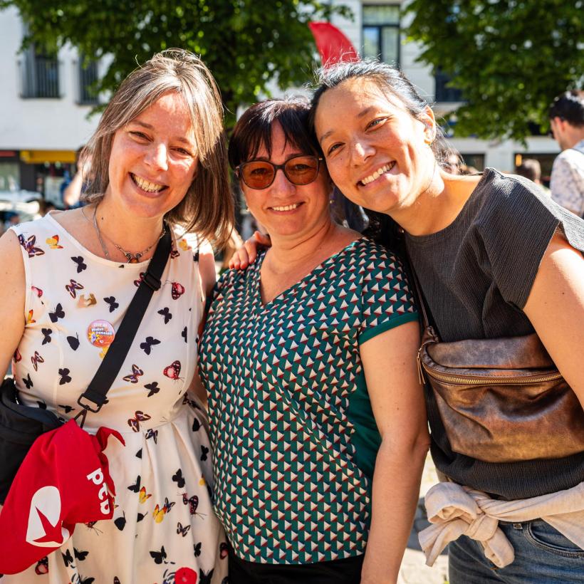 3 femmes membres du PTB qui posent ensemble lors d'un événement