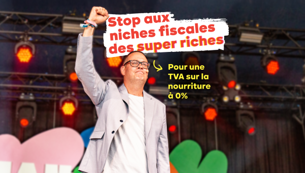 Raoul Hedebouw avec le poing levé sur le podium de ManiFiesta