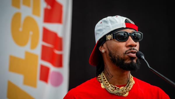 Vakbondsleider Chris Smalls op ManiFiesta. Hij spreekt in een microfoon tijdens een debat.