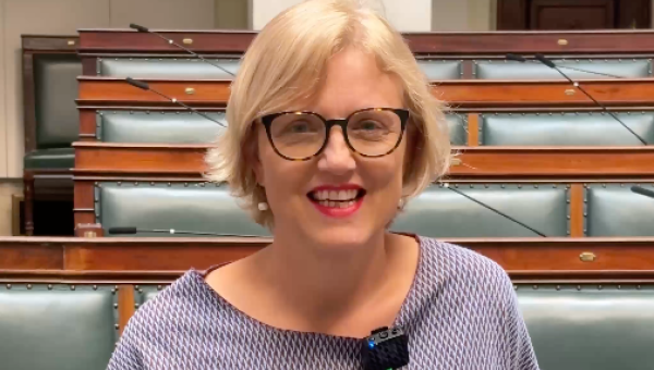 Sofie Merckx devant les sièges de la Chambre, sourit à la caméra